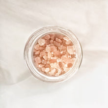 Load image into Gallery viewer, Top view of himalayan salt granules foot soak with rosemary on neutral background
