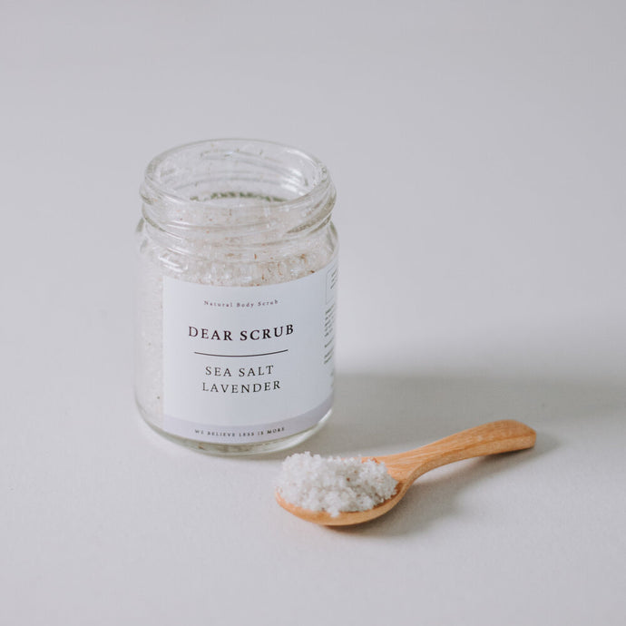 Sea Salt lavender body scrub with wooden spoon and neutral background